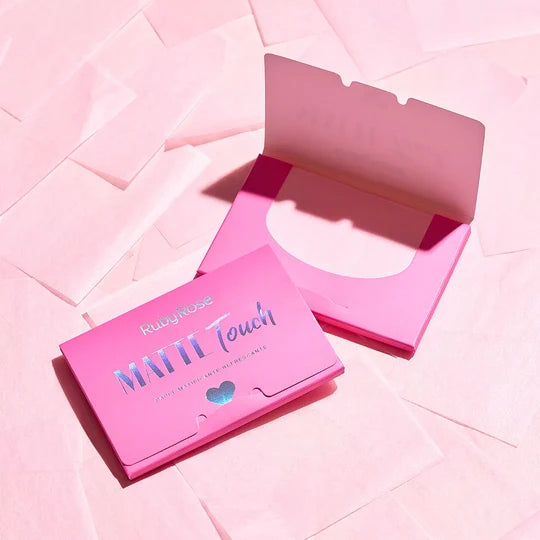 Papel matificante Matte Touch Ruby Rose en estuche rosado abierto, acompañado de hojas para controlar el exceso de oleosidad del rostro.