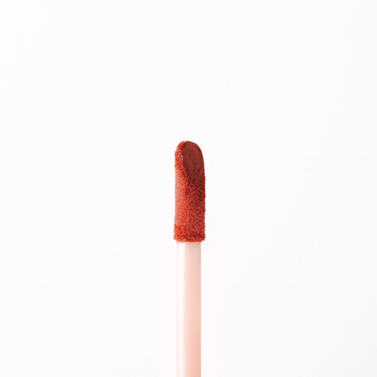 Aplicador de Ruby Rose Soft Focus con producto en tono terracota.